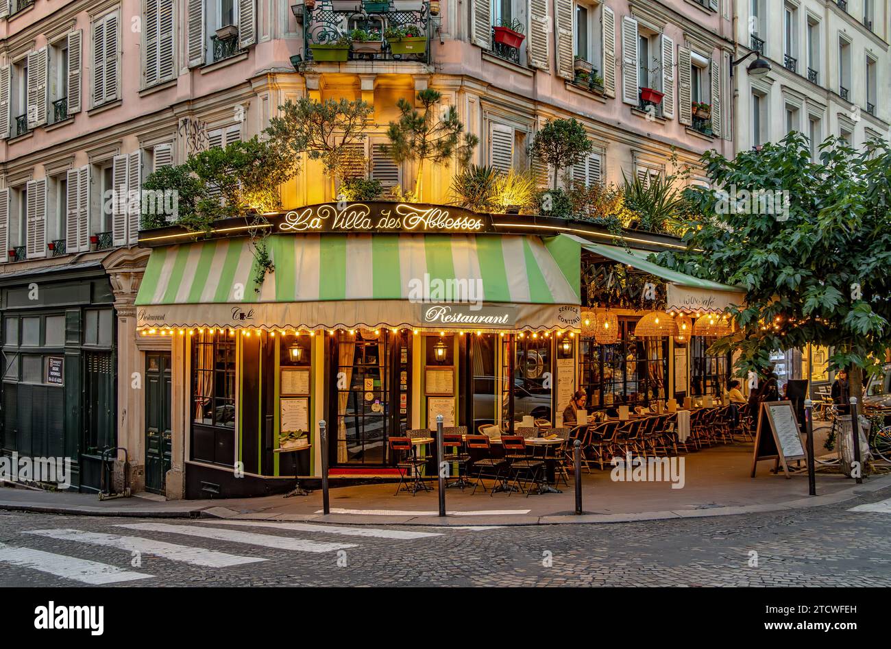 Tische und Stühle vor der La Villa des Abbesses ein französisches Restaurant/Bistro in der Rue des Abbesses, Montmartre im 18. Arrondissement von Paris Stockfoto