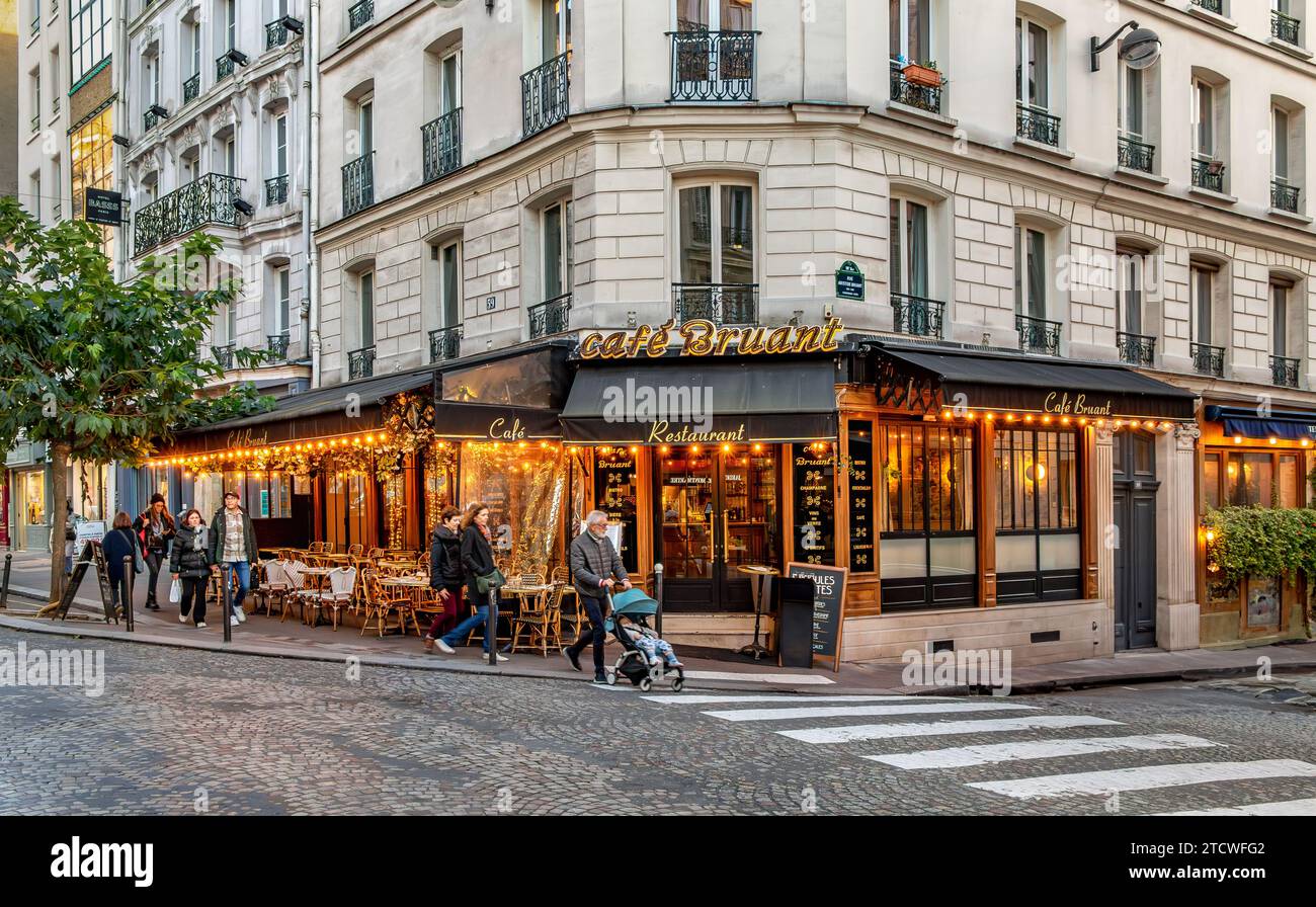 Leute gehen vorbei am Café Bruant, einem Restaurant/Café in der Rue des Abbesses in Montmartre im 18. Arrondissement von Paris, Frankreich Stockfoto