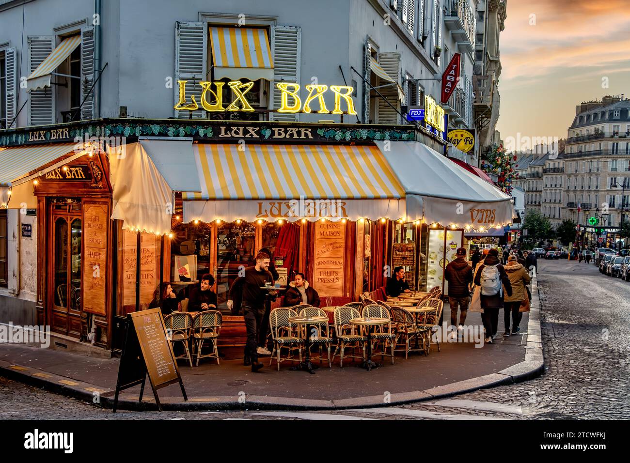 Ein Kellner serviert in der Lux Bar, einem Restaurant/Café in der Rue Lepic in Montmartre im 18. Arrondissement von Paris, Frankreich Stockfoto