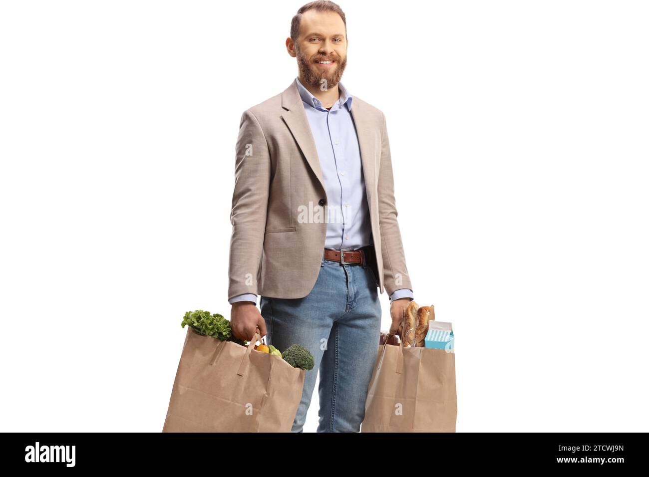 Lächelnder junger Mann, der Einkaufstaschen isoliert auf weißem Hintergrund trägt Stockfoto