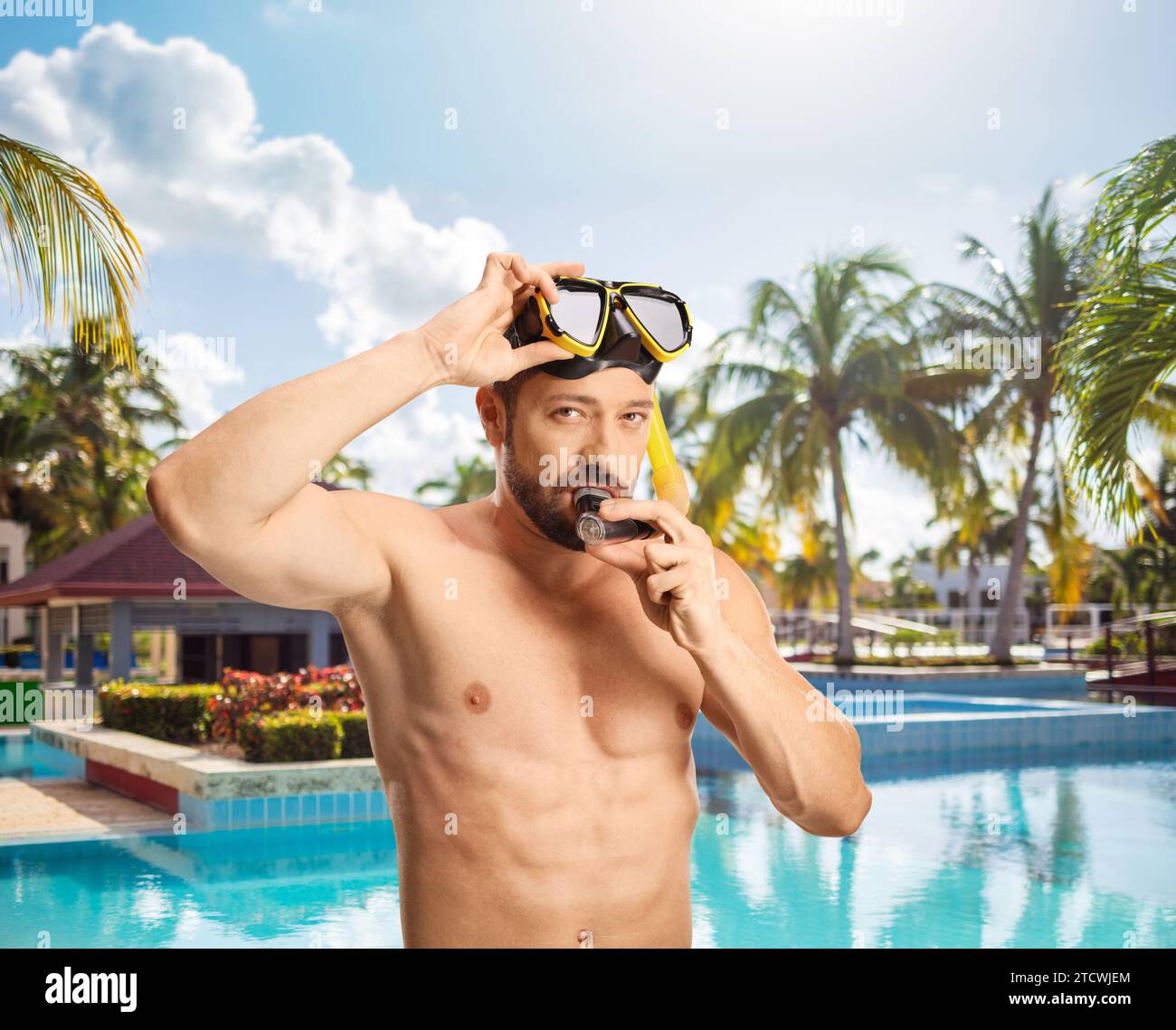 Junger Mann, der eine Tauchermaske an einem Schwimmbad anzieht Stockfoto