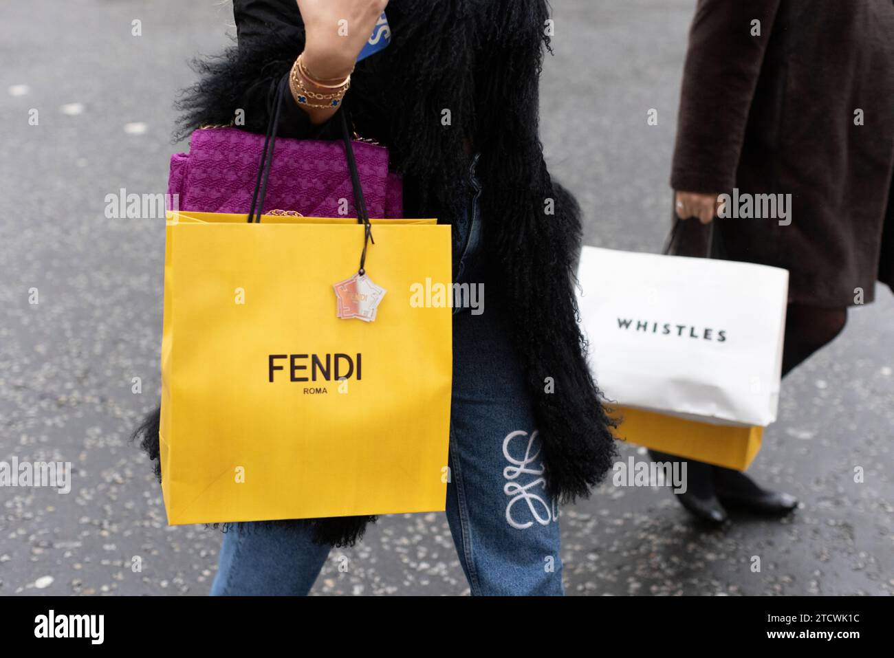 Shopper mit FENDI und Whistles Kleidersäcken von Designermarken im Londoner West End, England, Großbritannien Stockfoto