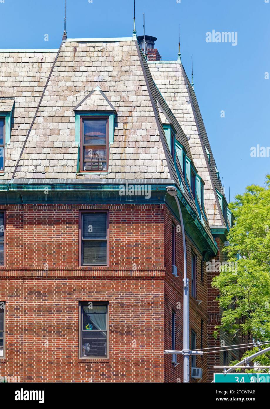 Das Hayes Court, ein von Andrew Thomas entworfener Garten-Apartmentkomplex im Jackson Heights Historic District, ist mit einem Dach aus Mansard gekrönt. Stockfoto