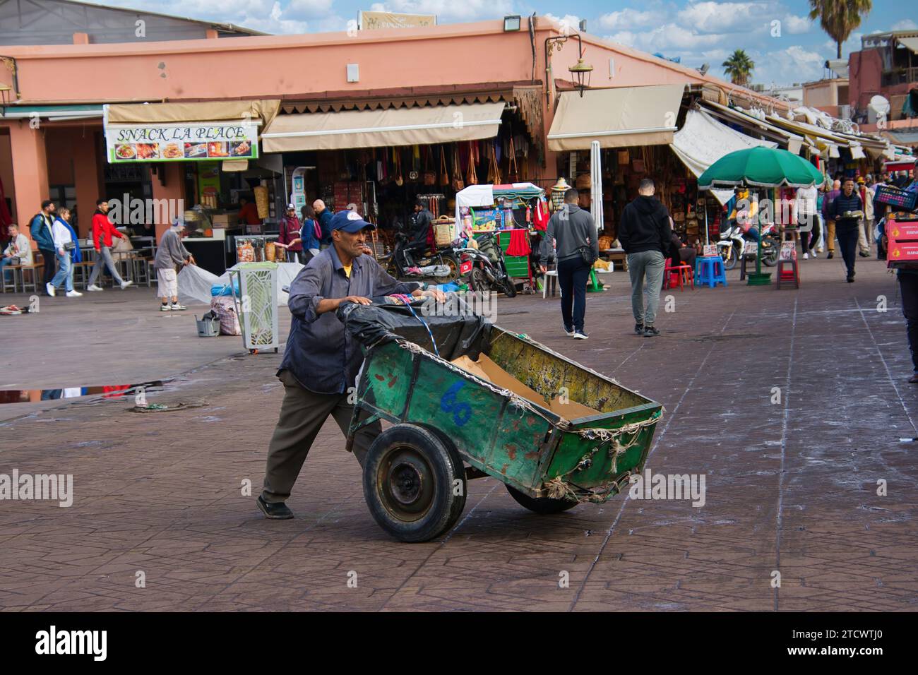 Im Alltag in Marrakesch schiebt ein Mann seinen Transportwagen Stockfoto