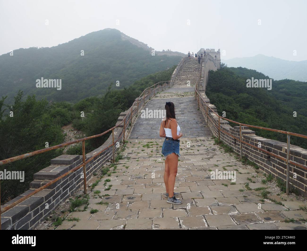 Eine Reisende Frau, die von der Kamera wegschaut, an der großen Mauer von China Stockfoto