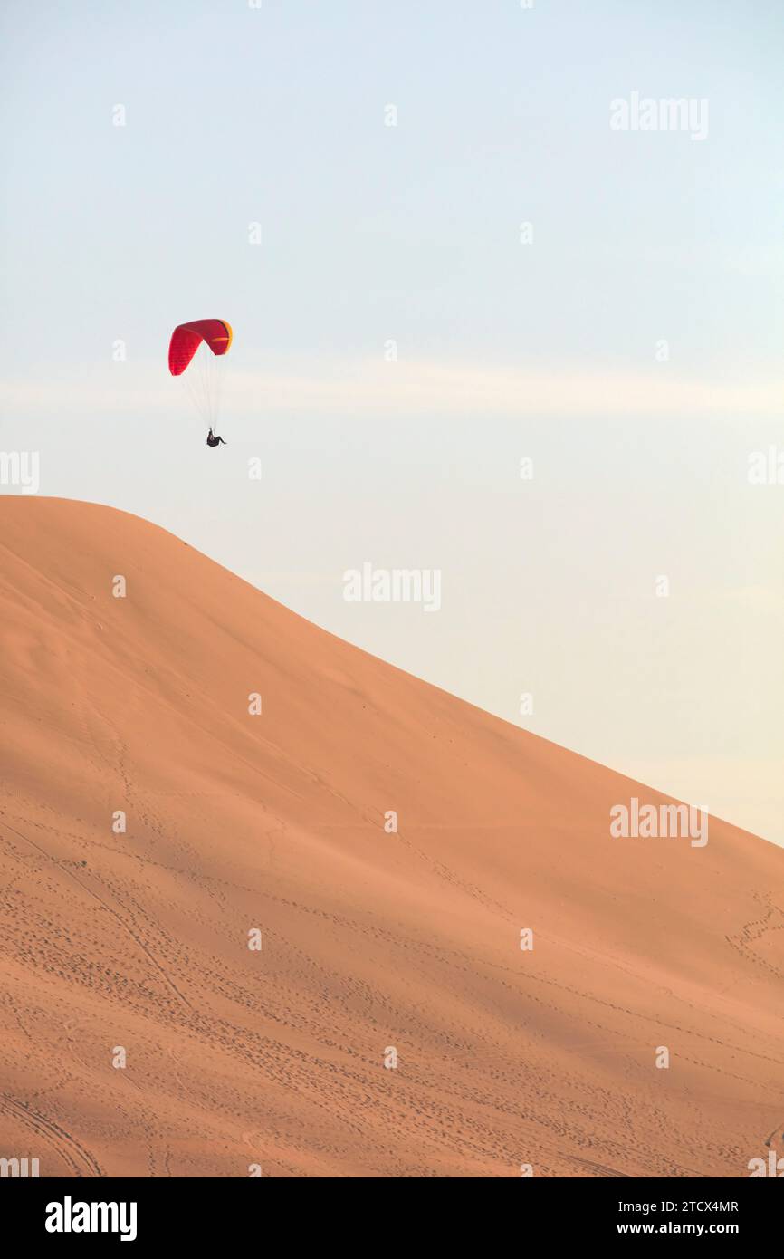 Paraglading in der Wüste Huacachina bei Sonnenuntergang, Ica, Peru. Stockfoto