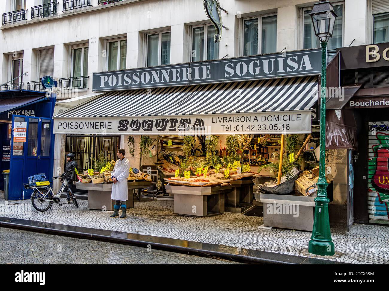 Ein Fischhändler, der vor seinem Laden stand, Poissonnerie Soguisa in der Rue Montorgueil, Paris, Frankreich Stockfoto