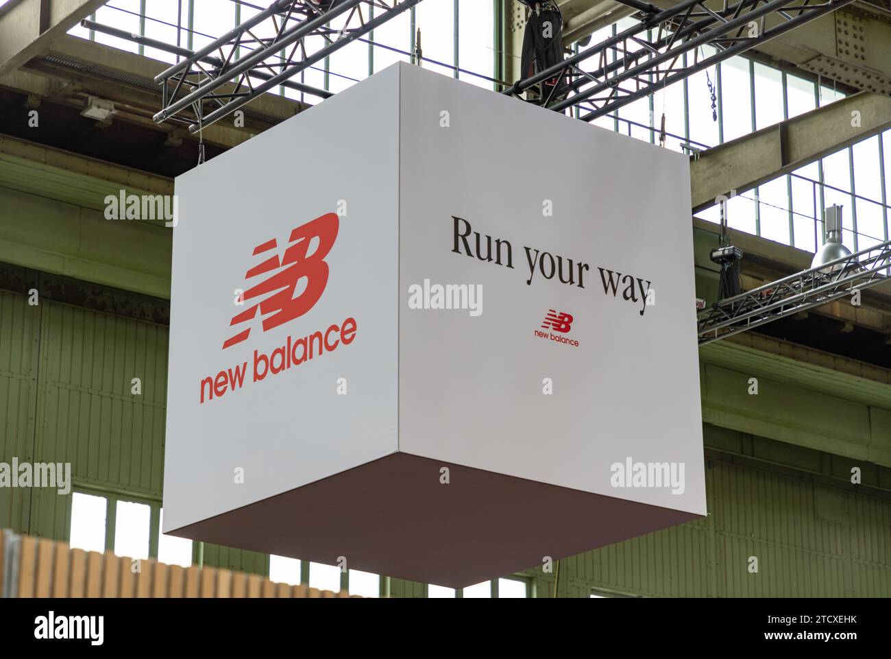 Ein Bild eines großen New Balance Logos auf einem weißen Würfel, der von der Decke hängt. Stockfoto