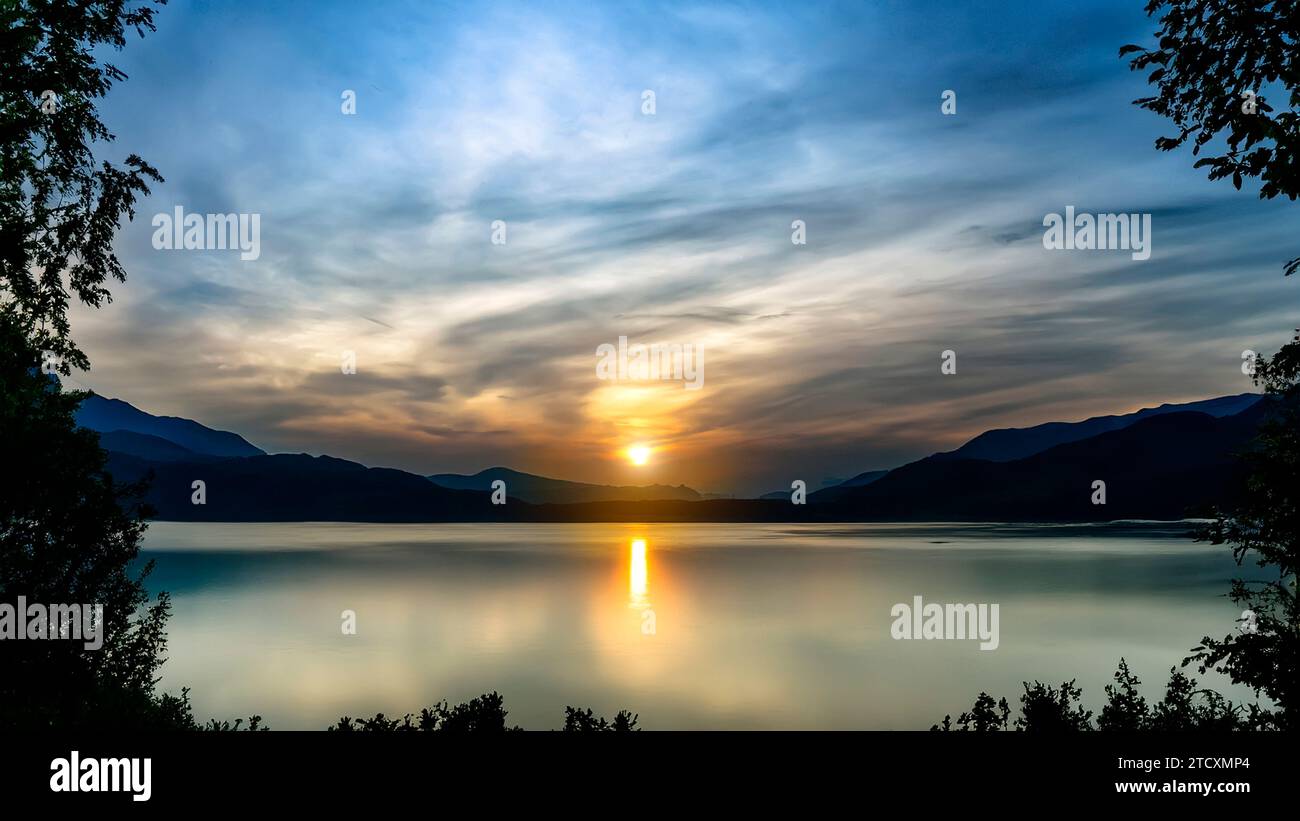 Blick auf den See bei Sonnenaufgang können Sie die Berge und Bäume sehen, die einen Rahmen bilden Stockfoto