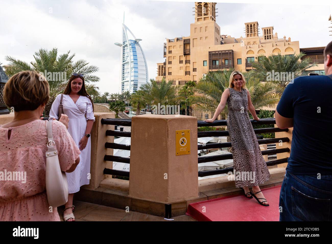 Dubai, Vereinigte Arabische Emirate. Dezember 2023. Touristen machen Fotos mit Burj Al Arab im Hintergrund von Souk Madinat Jumeirah, einem Markt in einem alten Teil der Stadt im Zentrum von Dubai, an einem heißen Abend. Quelle: SOPA Images Limited/Alamy Live News Stockfoto