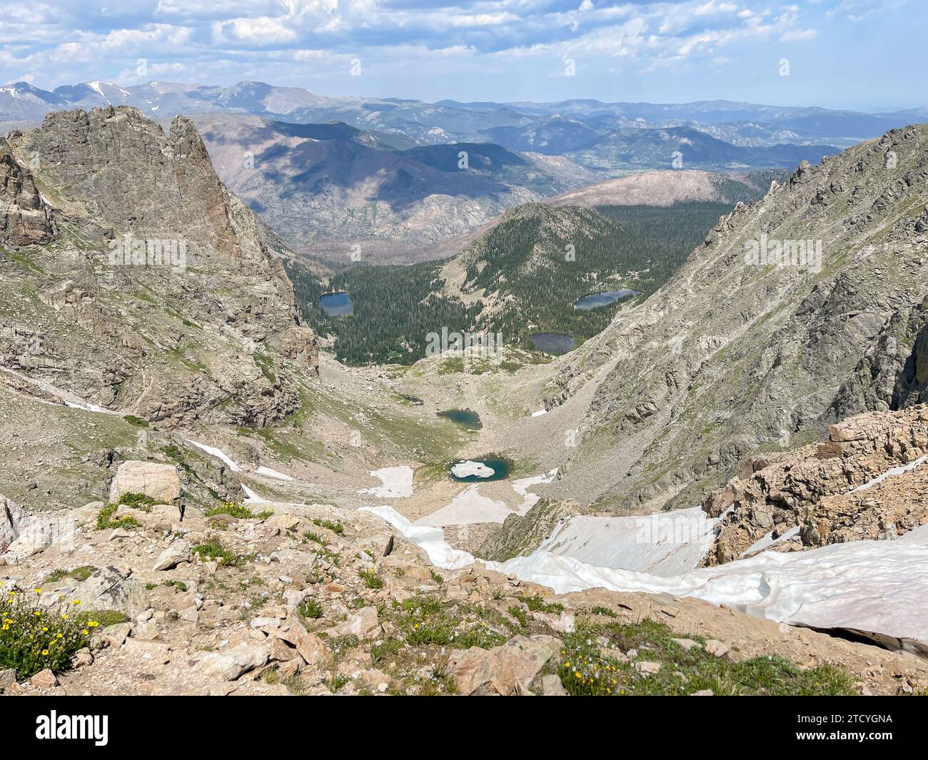 Dieser Blick vom Rocky Mountain National Park aus blickt auf ein grünes Tal und alpine Seen und fängt das Wesen der hochgelegenen Wildnis ein. Stockfoto
