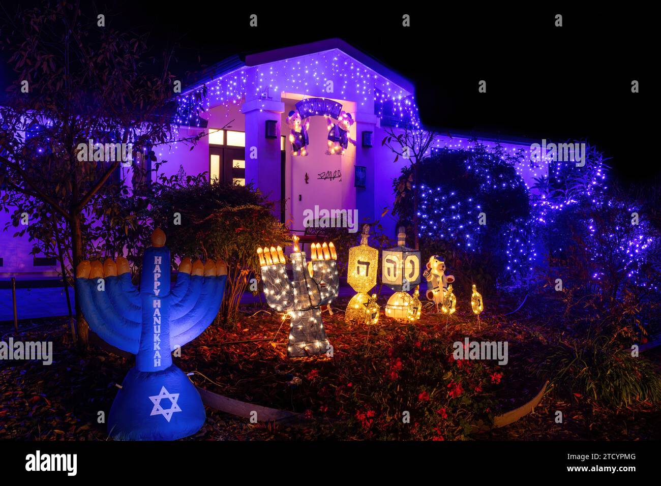 Fröhliche Hanukkah-Nachtdekoration mit Menorahs und Dreidels. Stockfoto