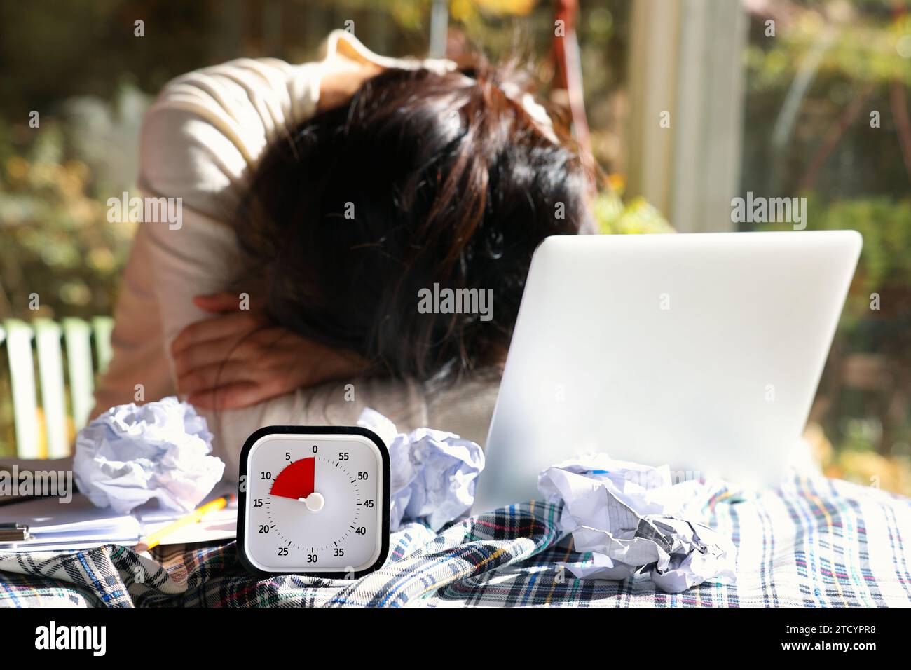 Verzweifelte Frau mit einer bevorstehenden Frist, die mit dem Gesicht nach unten auf dem Tisch liegt Stockfoto