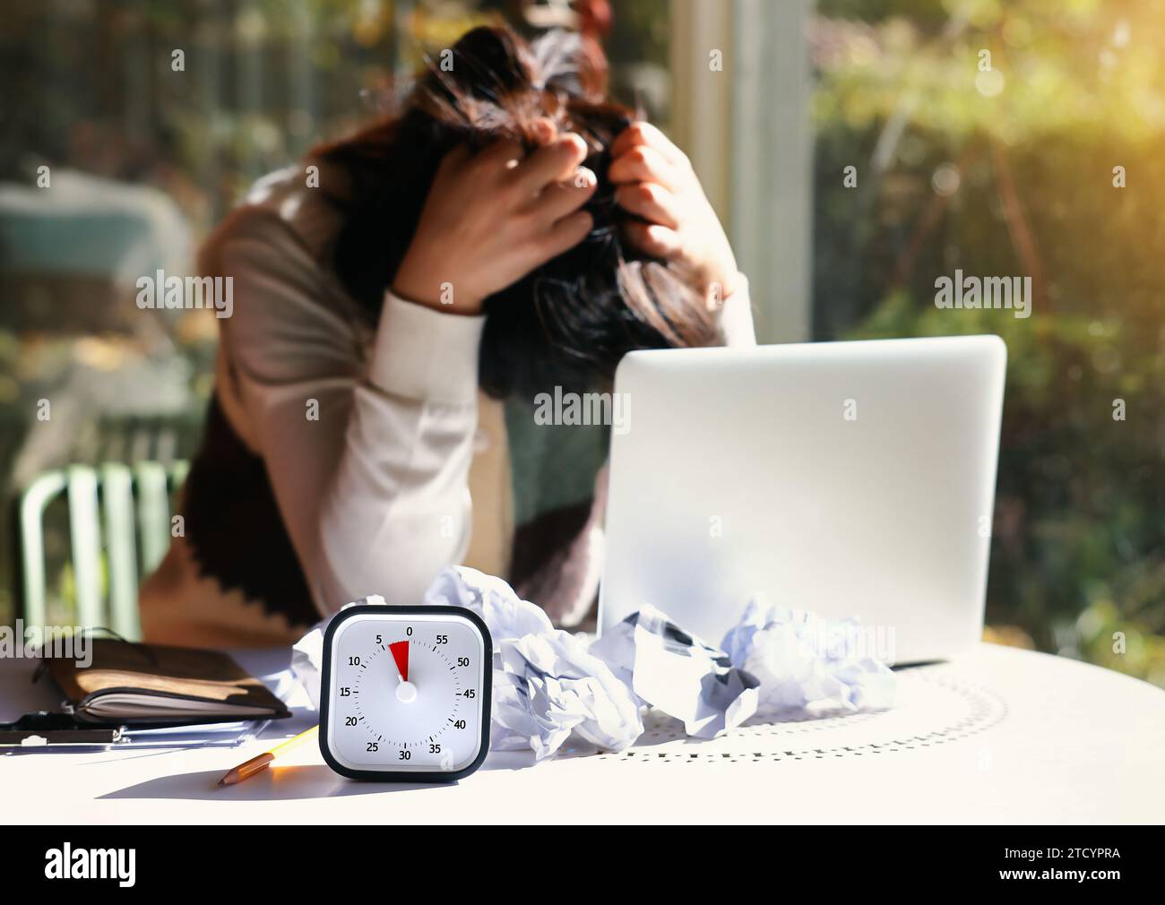 Verzweifelte Frau mit einer bevorstehenden Frist, die mit dem Gesicht nach unten auf dem Tisch liegt Stockfoto