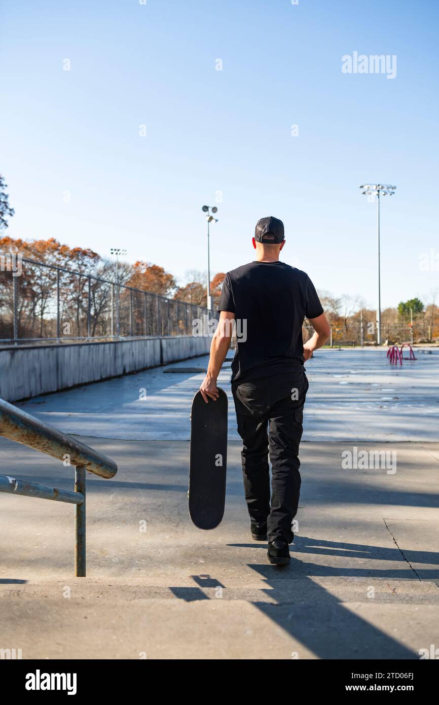 Alleinmann, der im Herbst durch den Skatepark geht Stockfoto