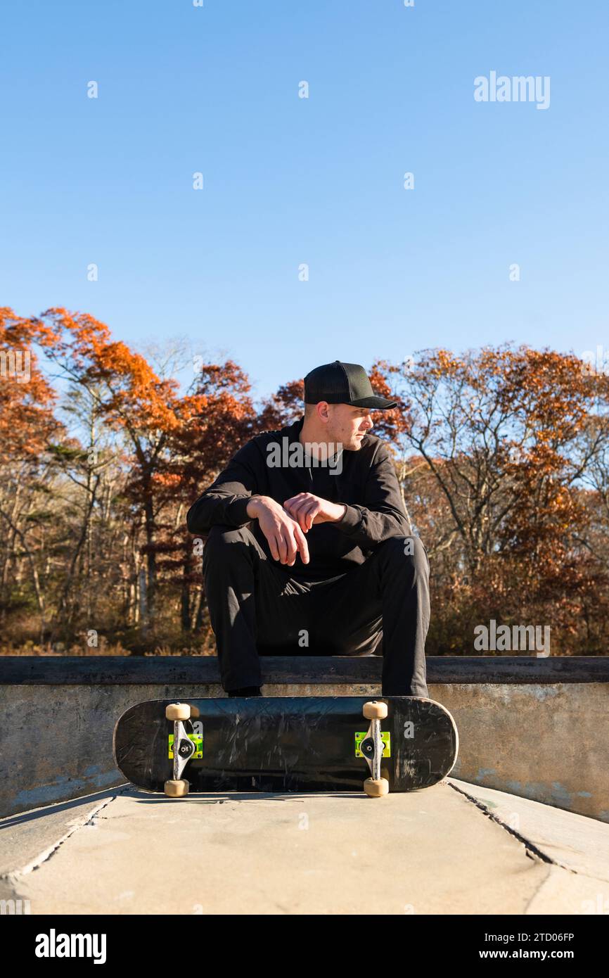 Solomann sitzt im Herbst im A Skatepark Stockfoto