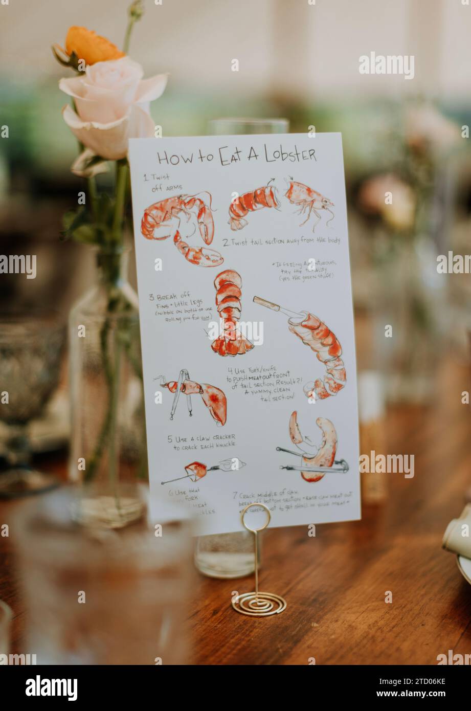 Schild, auf dem erklärt wird, wie man Hummer auf einem Tisch bei der Hochzeit isst Stockfoto