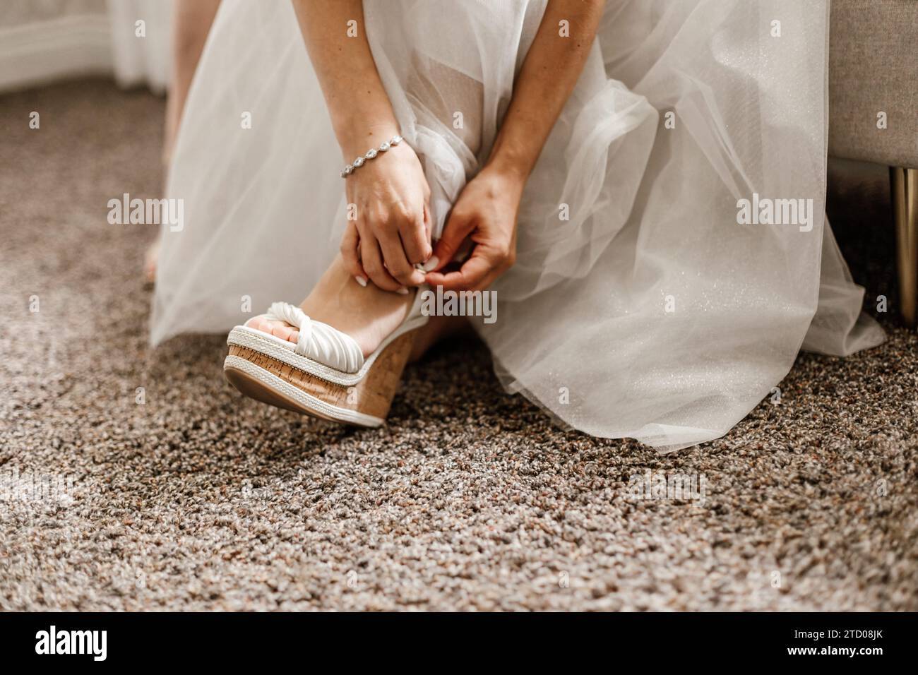 Braut macht sich fertig und zieht Hochzeitsschuhe an Stockfoto