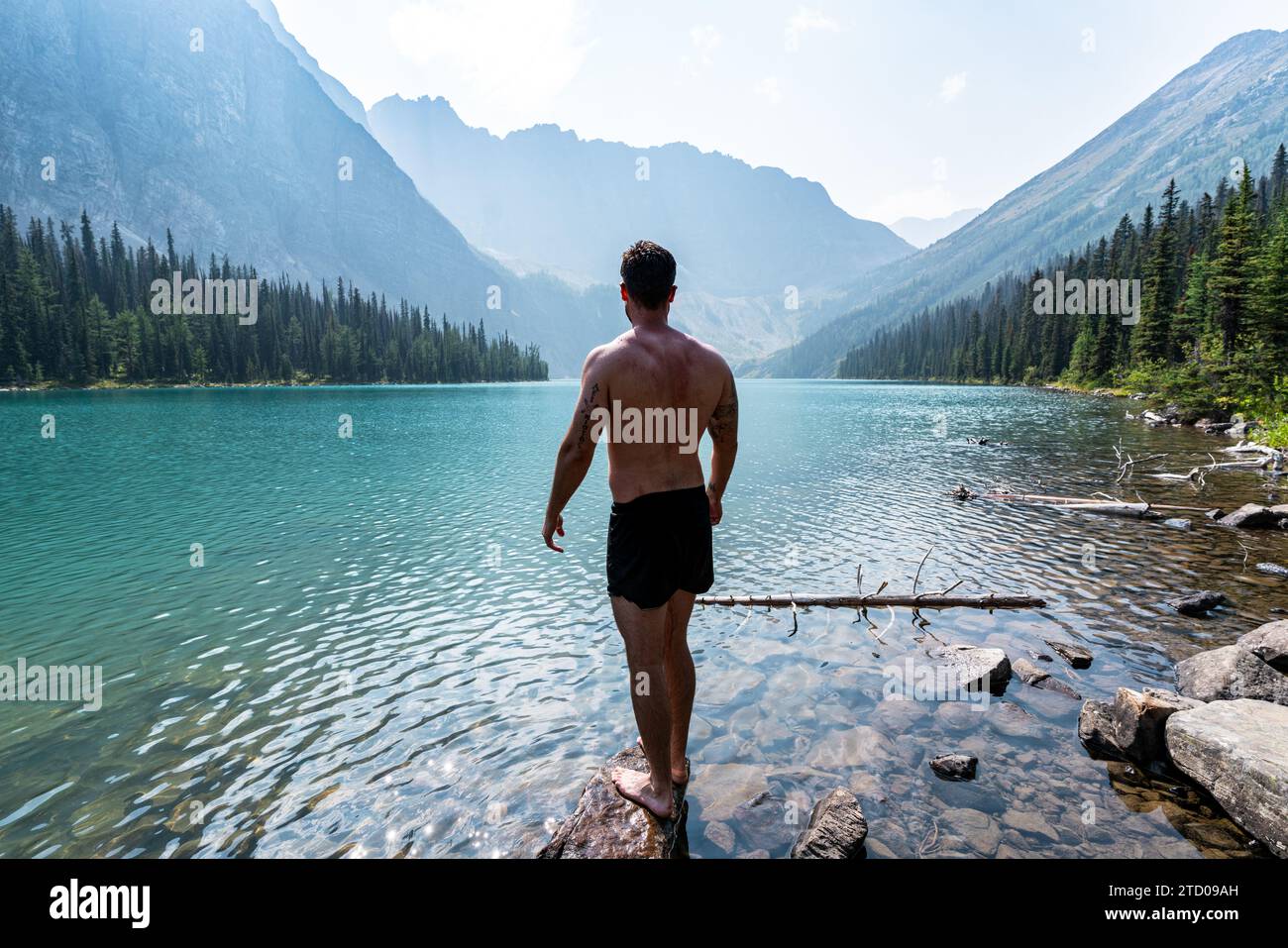 Wanderer kühlt am See während des Wanderabenteuers im Sommer ab Stockfoto