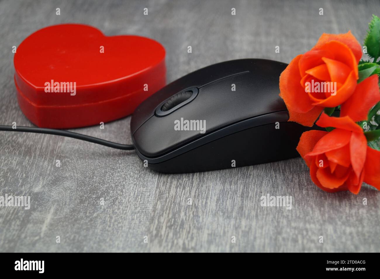 Rotes Herz und rote Rosen mit Computermaus, symbolisches Bild der Liebe online Stockfoto