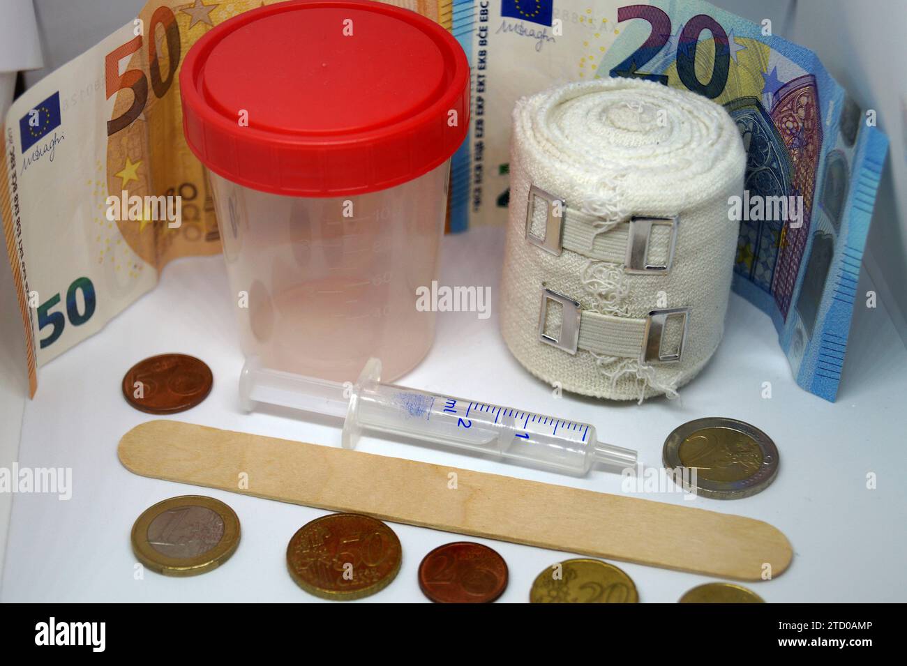 Tasse, Verband, Spritze, Holzspachtel mit Euro, symbolisches Bild für medizinische Kosten Stockfoto