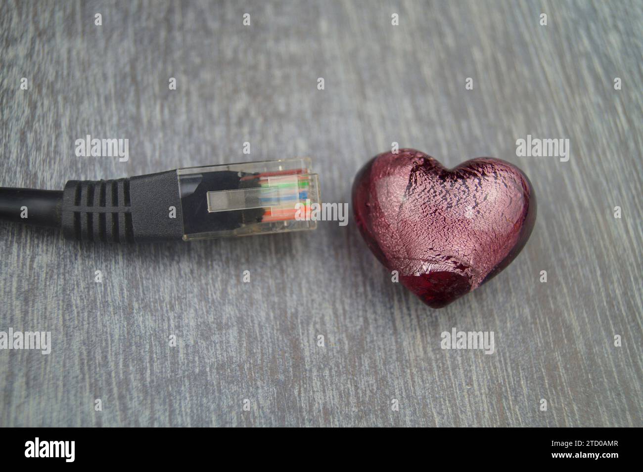 Herz mit schwarzem Internetkabel, symbolisches Bild der Liebe online Stockfoto