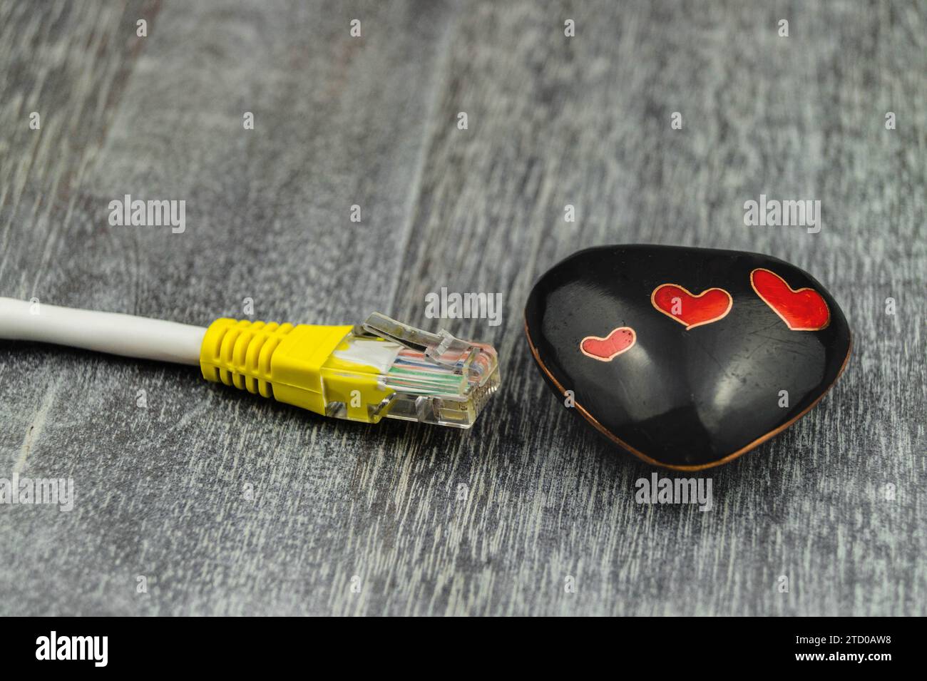 Herz mit gelbem Internetkabel, symbolisches Bild der Liebe online Stockfoto