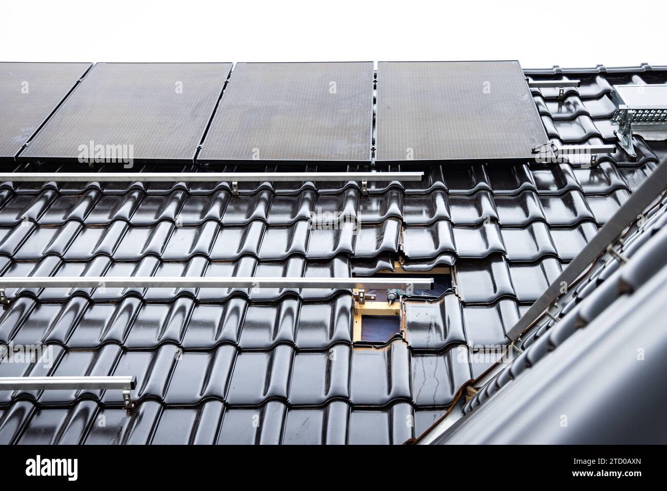 Installation von Solarpaneelen auf einem Dach eines Wohnhauses wird gerade durchgeführt Stockfoto