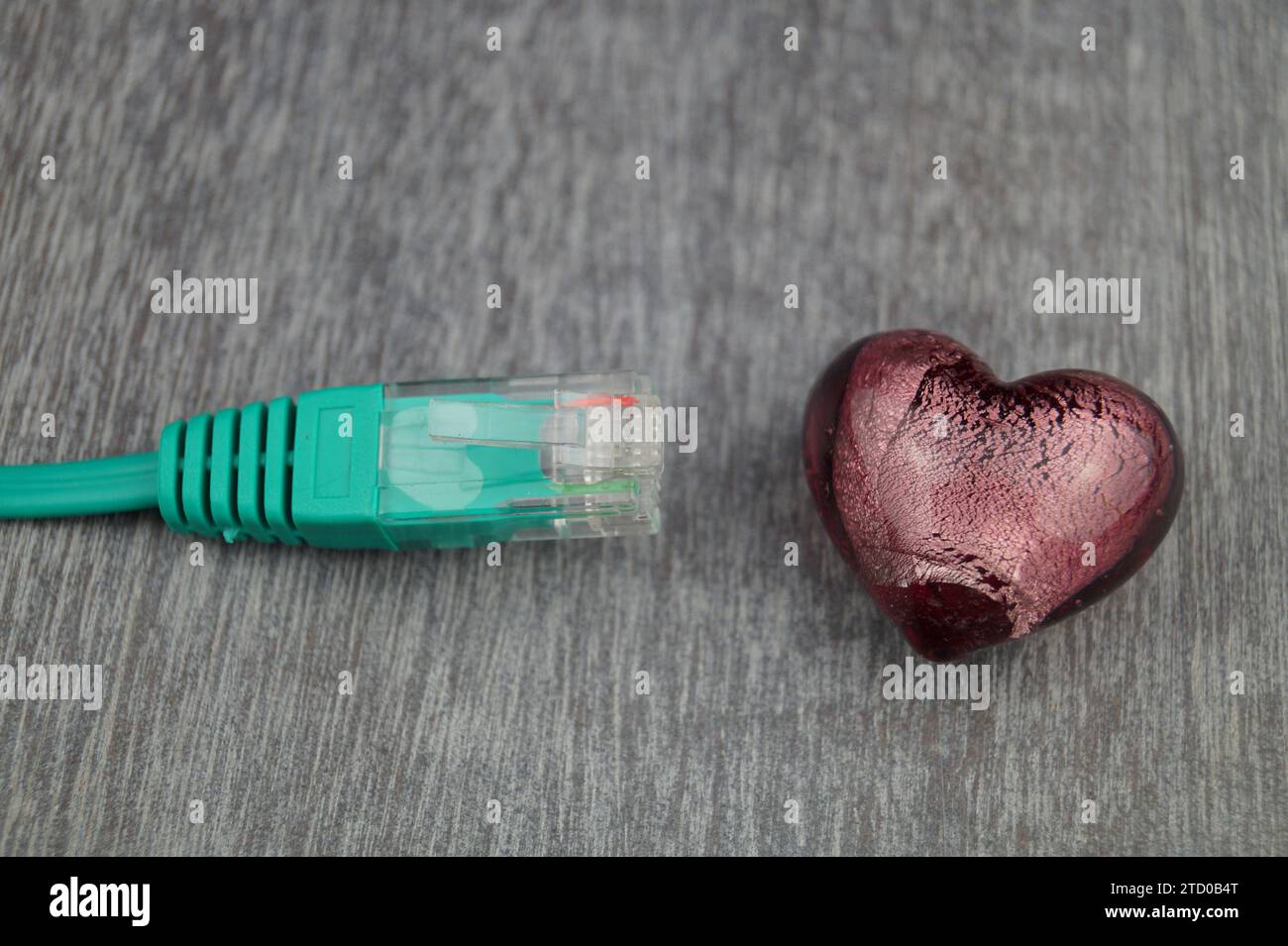 Herz mit grünem Internetkabel, symbolisches Bild der Liebe online Stockfoto