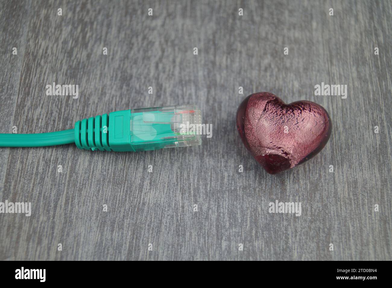 Herz mit grünem Internetkabel, symbolisches Bild der Liebe online Stockfoto