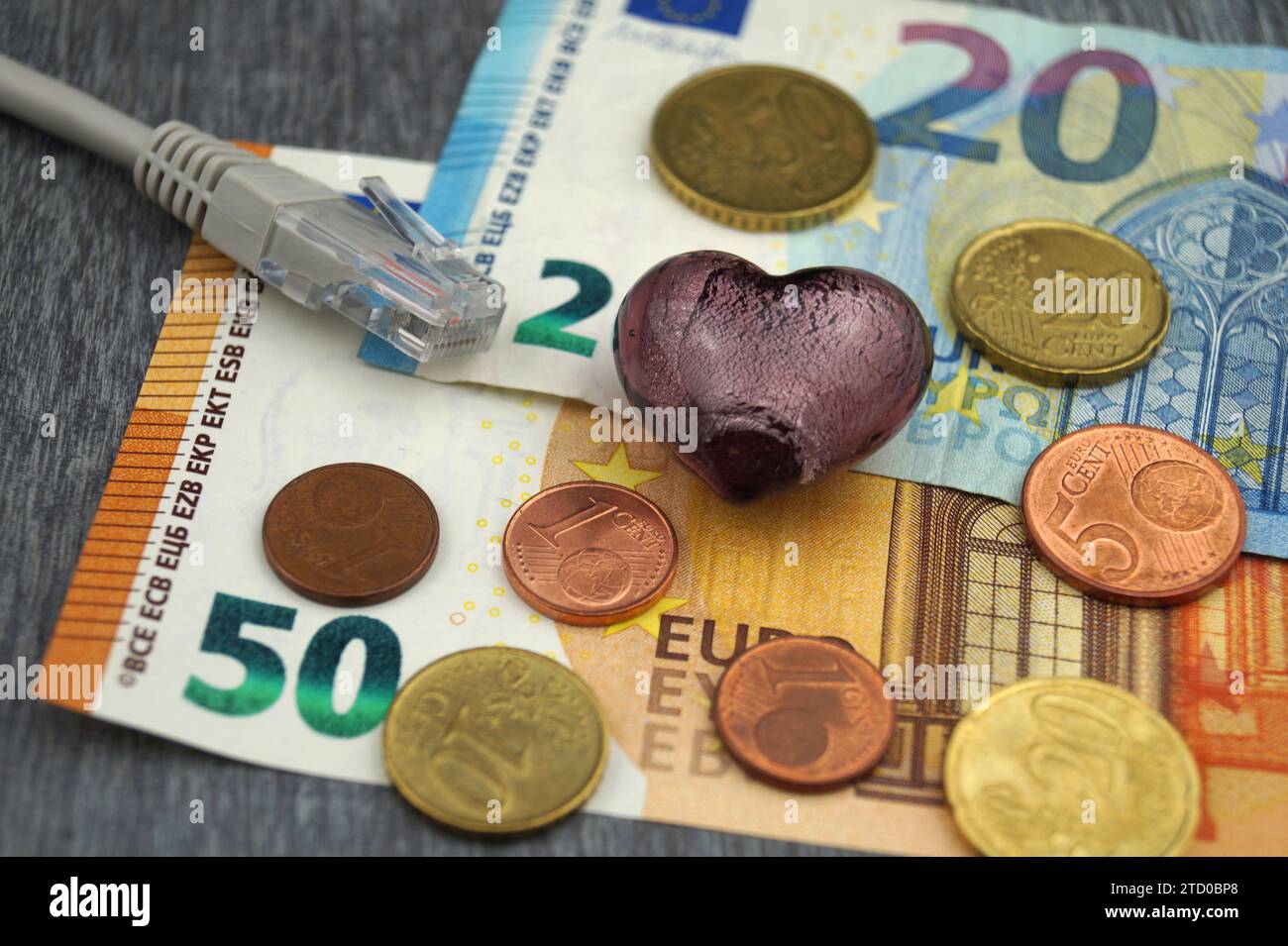 Herz mit Internetkabel und Euro, symbolisches Bild der Liebe online Stockfoto