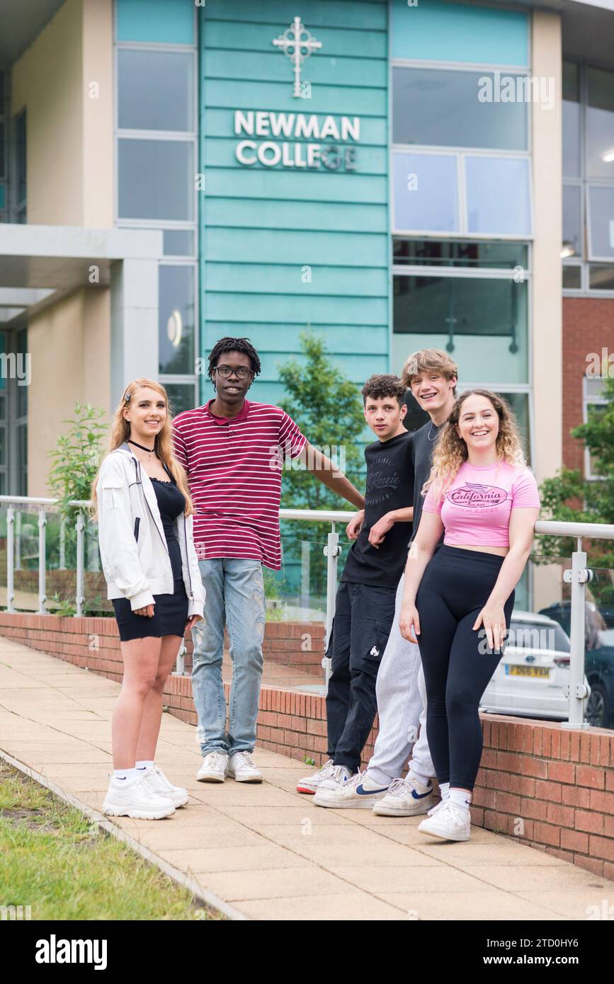 Die Schüler des Newman College in Brighton und Hove stehen draußen mit dem College-Schild im Hintergrund. Stockfoto