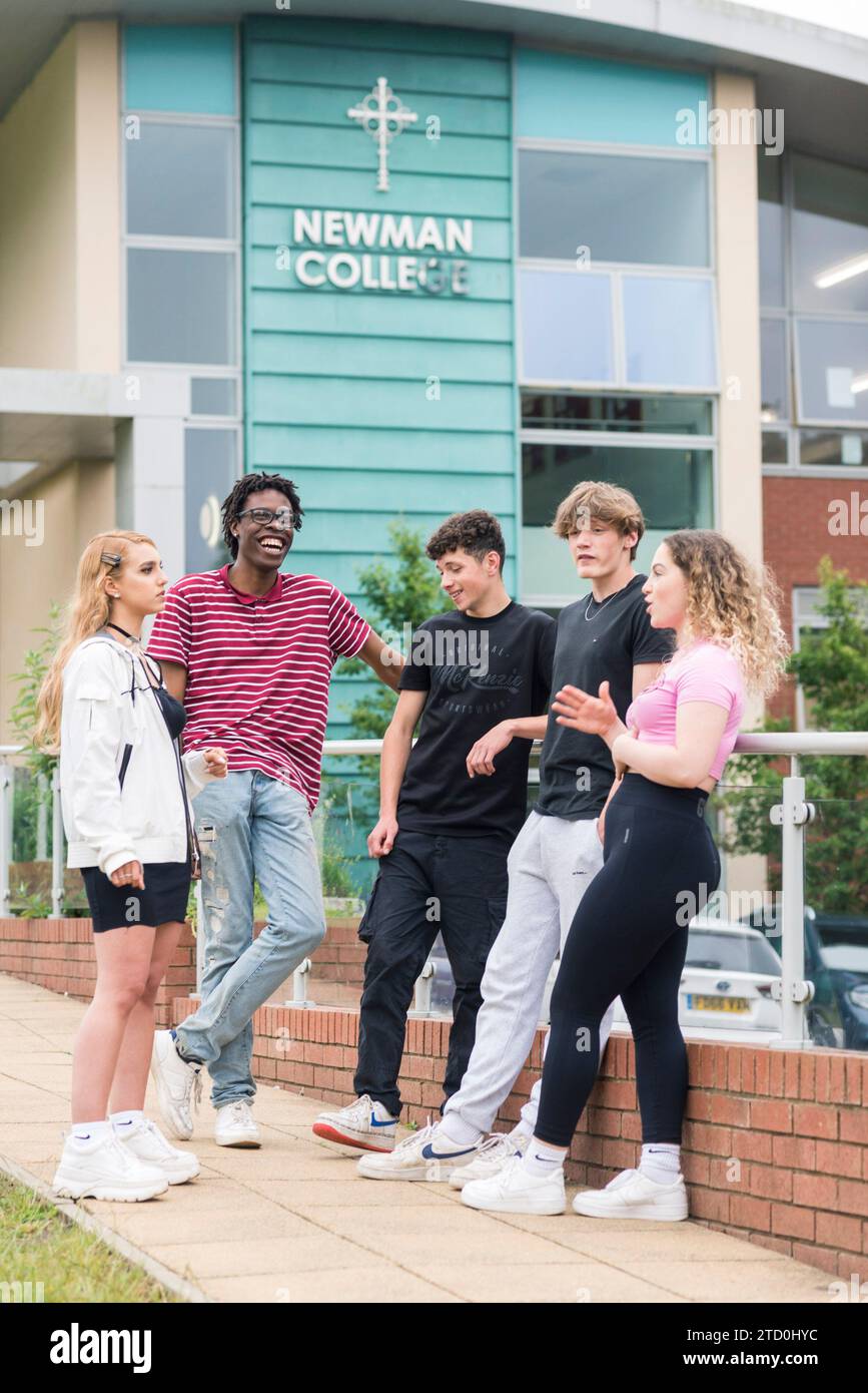 Die Schüler des Newman College in Brighton und Hove stehen draußen mit dem College-Schild im Hintergrund. Stockfoto
