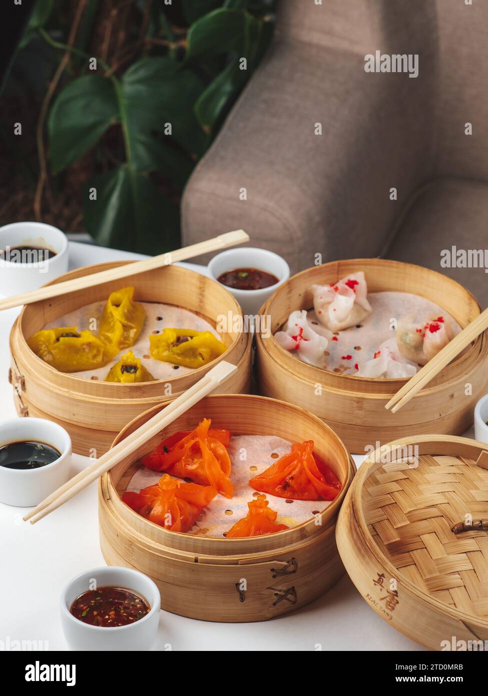Dim Sum Geschirrset. Traditionelles Asan-Brunch. Gedämpfte Knödelgerichte mit Sojasauce auf dem Hintergrund des Restauranttisches. Dim Sum traditionelle chinesische und japanische Küche. Stockfoto
