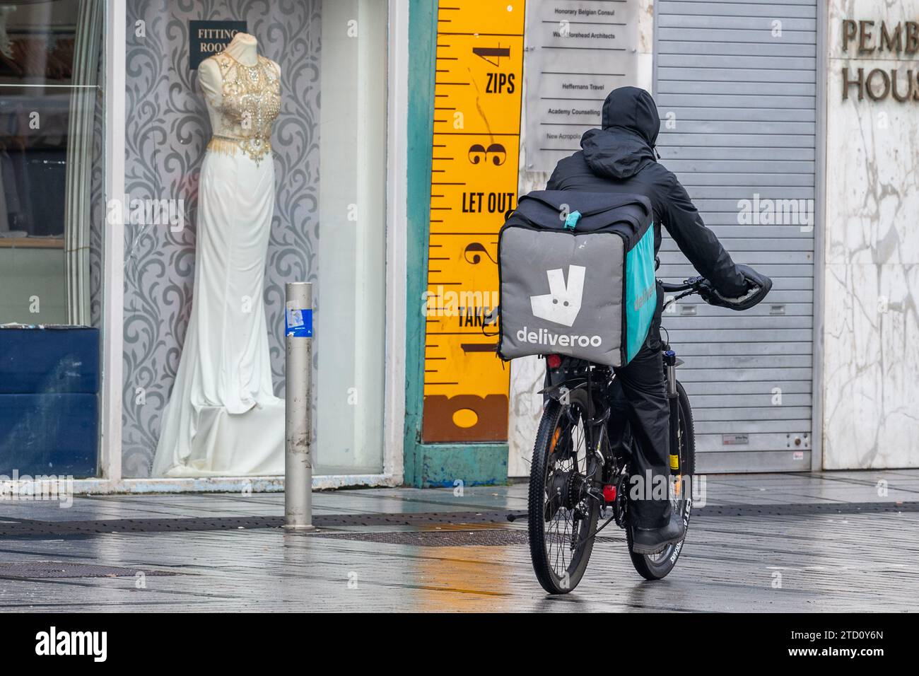 Deliveroo-Fahrer auf einem Push-Bike, der eine Essenslieferung in Cork, Irland, macht. Stockfoto