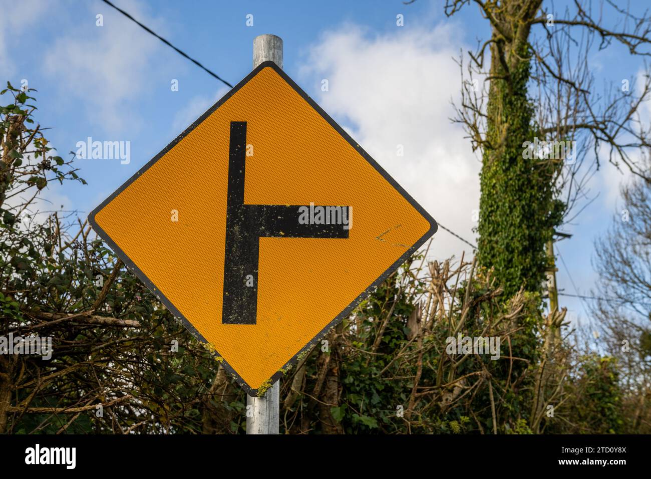 Irisches Richtungsschild, das eine Kreuzung vor der Hauptstraße nach rechts zeigt. Stockfoto