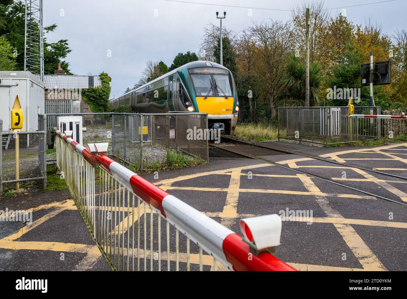 Der Irish Rail-Zug überquert einen Bahnübergang in County Limerick, Irland. Stockfoto