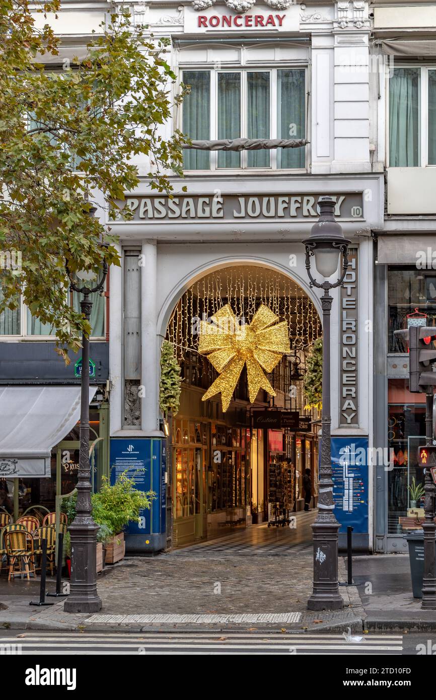Zwei Frauen und ein Hund überqueren die Straße am Eingang zur Passage Jouffroy am Boulevard Montmartre, einer der beliebtesten überdachten Gänge in Paris Stockfoto