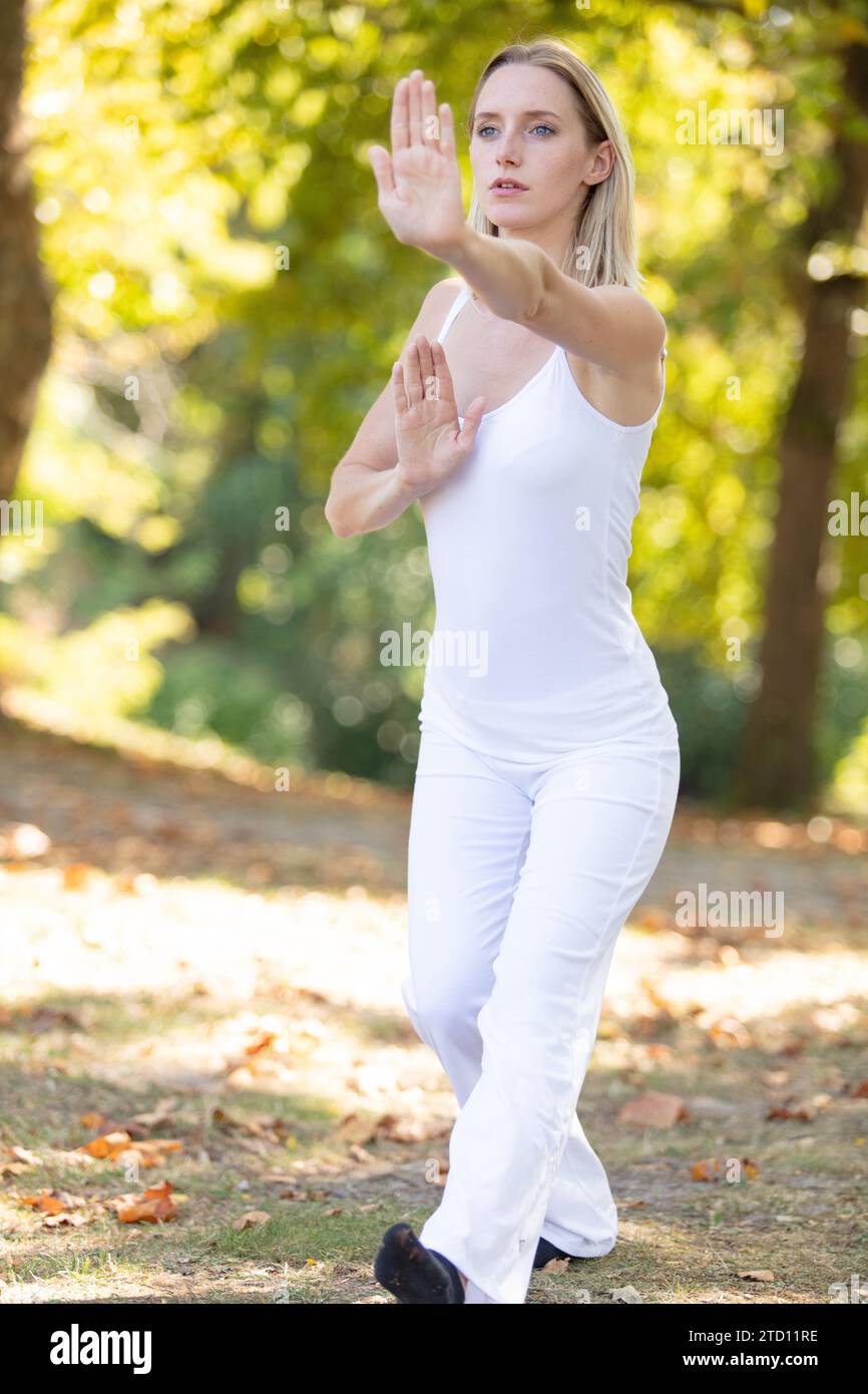 Junge kaukasische Frau, die draußen Tai Chi chuan betreibt Stockfoto
