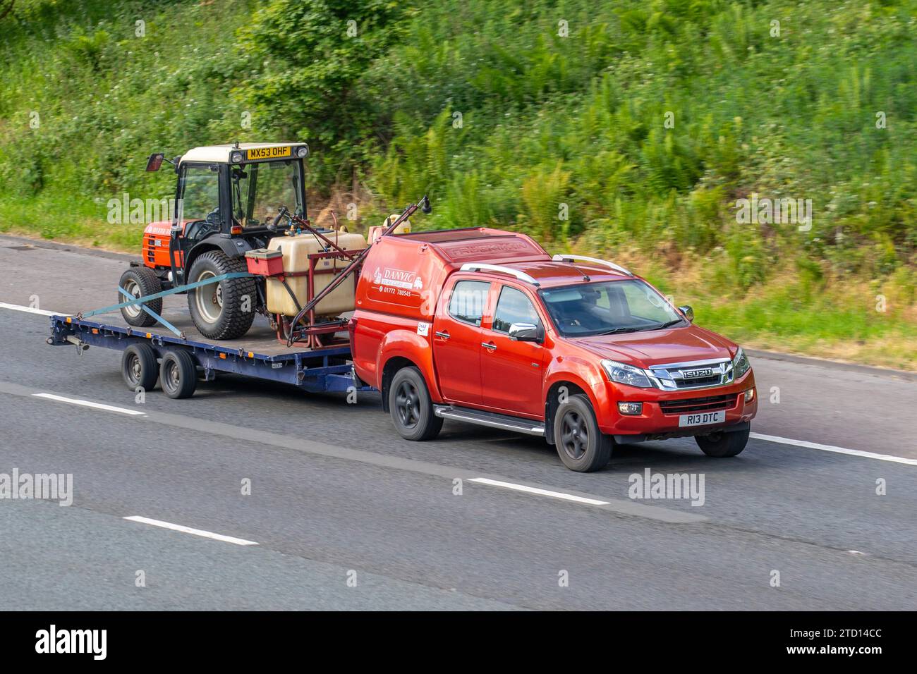 DASSELBE Società Accomandita Motori Endotermici, italienische Landmaschinen. Ein Traktor, der von Isuzu D-Max Utah Vision D/C TW Trbtd TD 163 4WD Red LCV Double Cab gezogen wird, nimmt 2499 ccm Diesel-Van auf, der im Großraum Manchester, Großbritannien, unterwegs ist Stockfoto