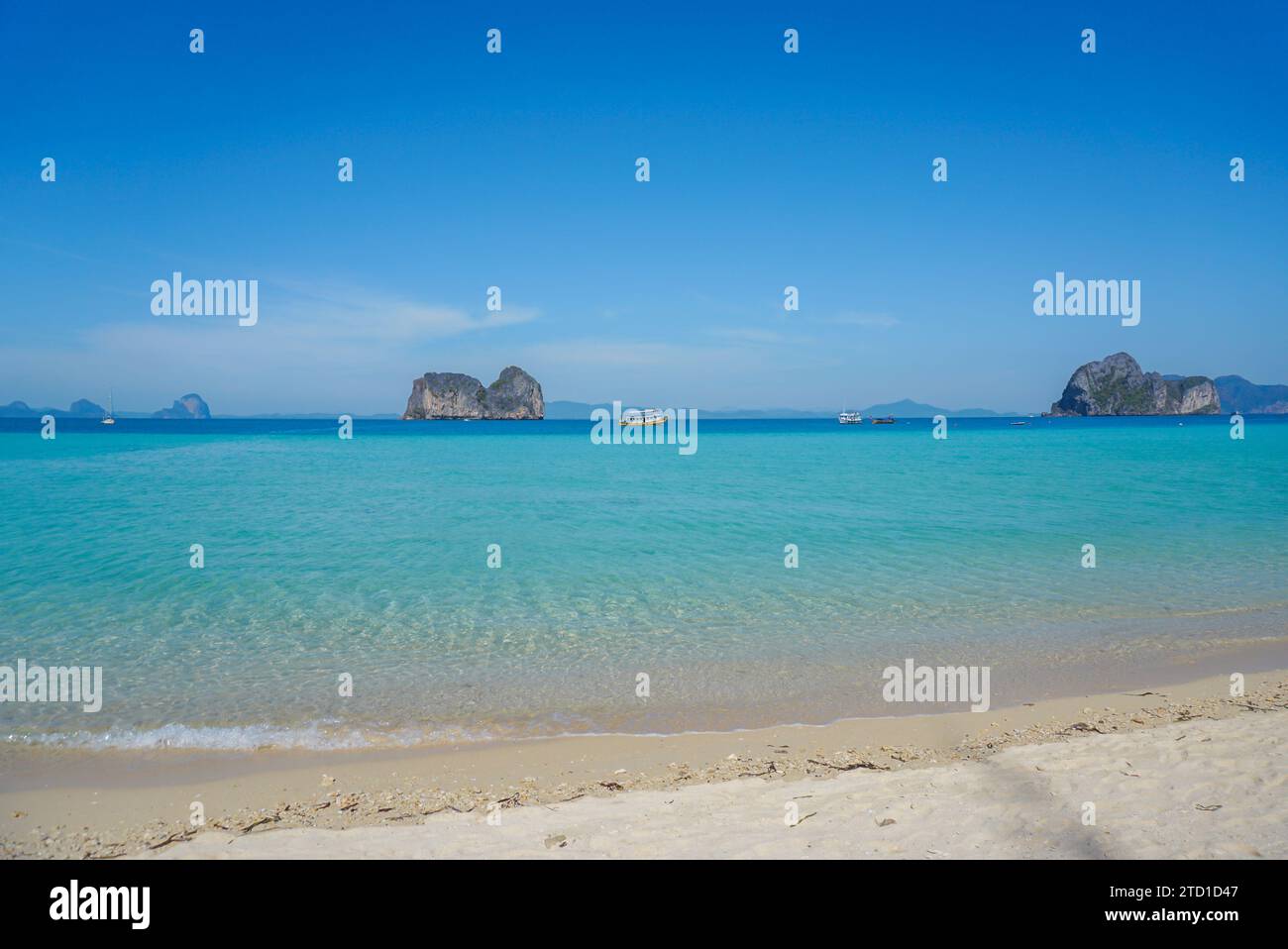Klares, wunderschönes Wasser an einem kleinen tropischen Strand in Thailand. Lebendige blaue Ozeanwellen mit weißem Sandstrand Hintergrund in Koh Ngai, Thailand. Stockfoto