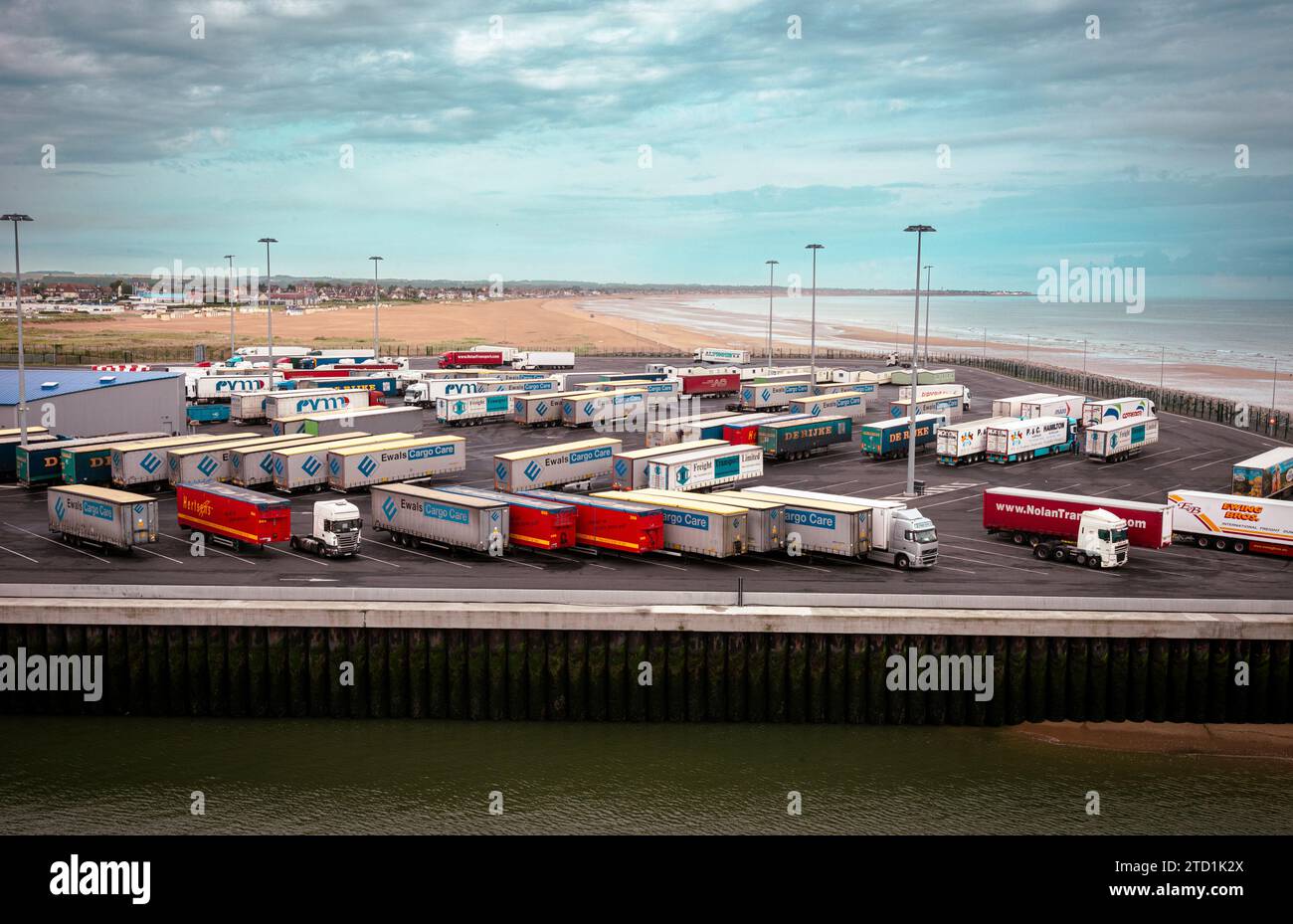 Auf einem Parkplatz in der Nähe des Fährhafens in Caen, der Normandie in Frankreich liegt, stehen mehrere LKW- und Containerreihen Stockfoto Auf einem Parkplatz in der Nähe des Fährhafens in Caen, der Normandie in Frankreich liegt, stehen mehrere LKW- und Containerreihen Stockfoto