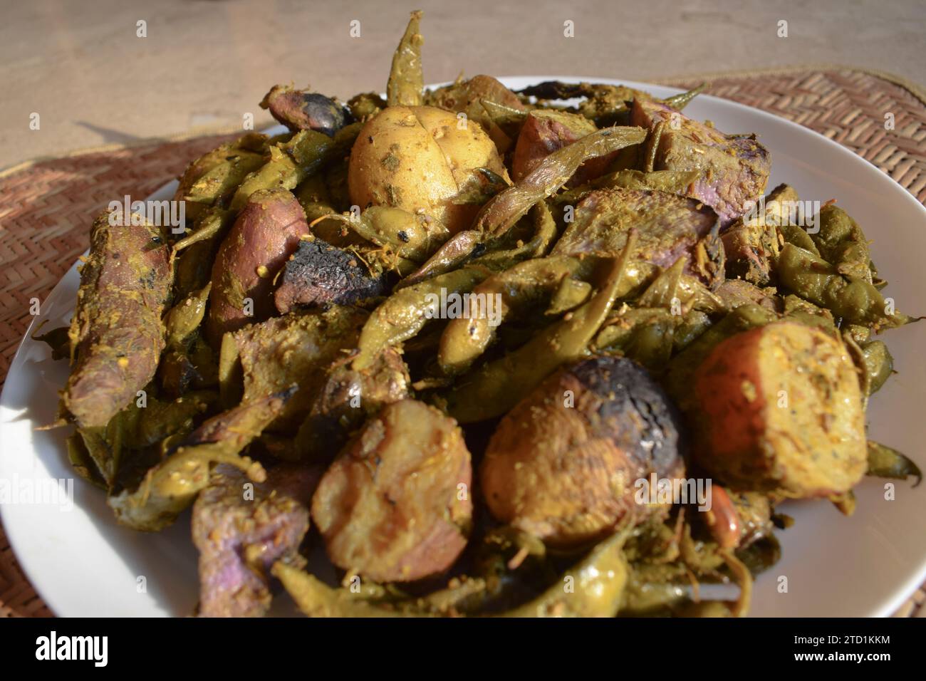 Umbadiyu ein traditionelles winterliches Gujarati-Spezialgericht, das mit Wintergemüse in einem Erdtopf, teilweise unterirdisch, gekocht wird und rauchiges Aroma und tas verleiht Stockfoto