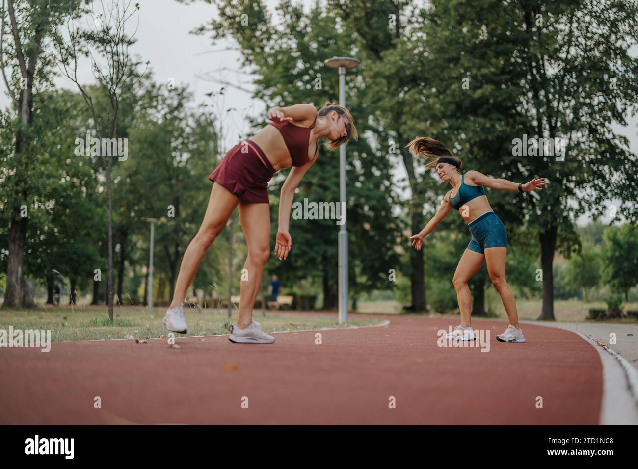 Fitte und flexible Mädchen mit beeindruckenden 360-Grad-Laufrädern in einem grünen Park. Inspirieren von Athleten für einen gesunden Lebensstil. Stockfoto