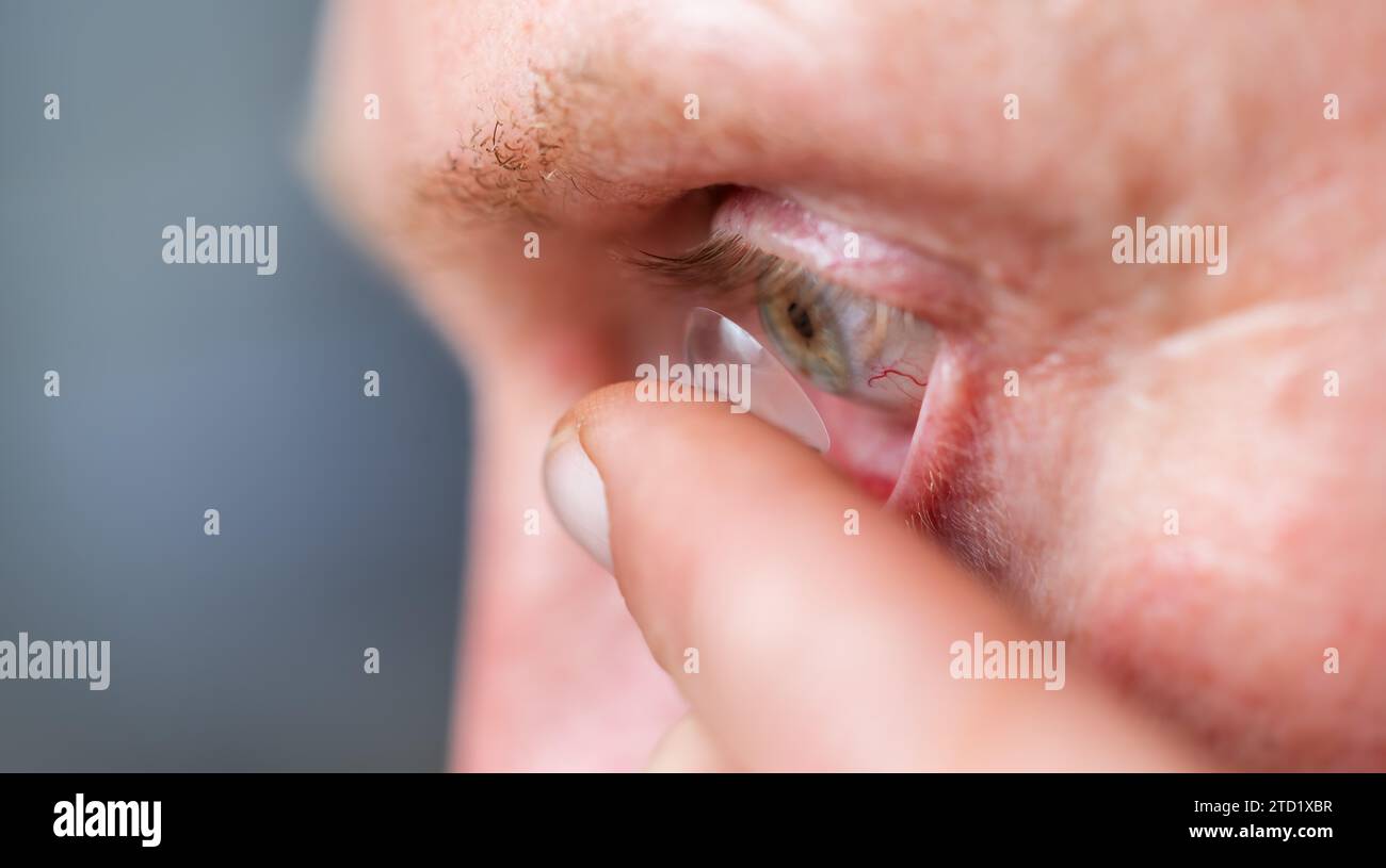 Mann, der Kontaktlinse ins rechte Auge steckt, Nahaufnahme Stockfoto