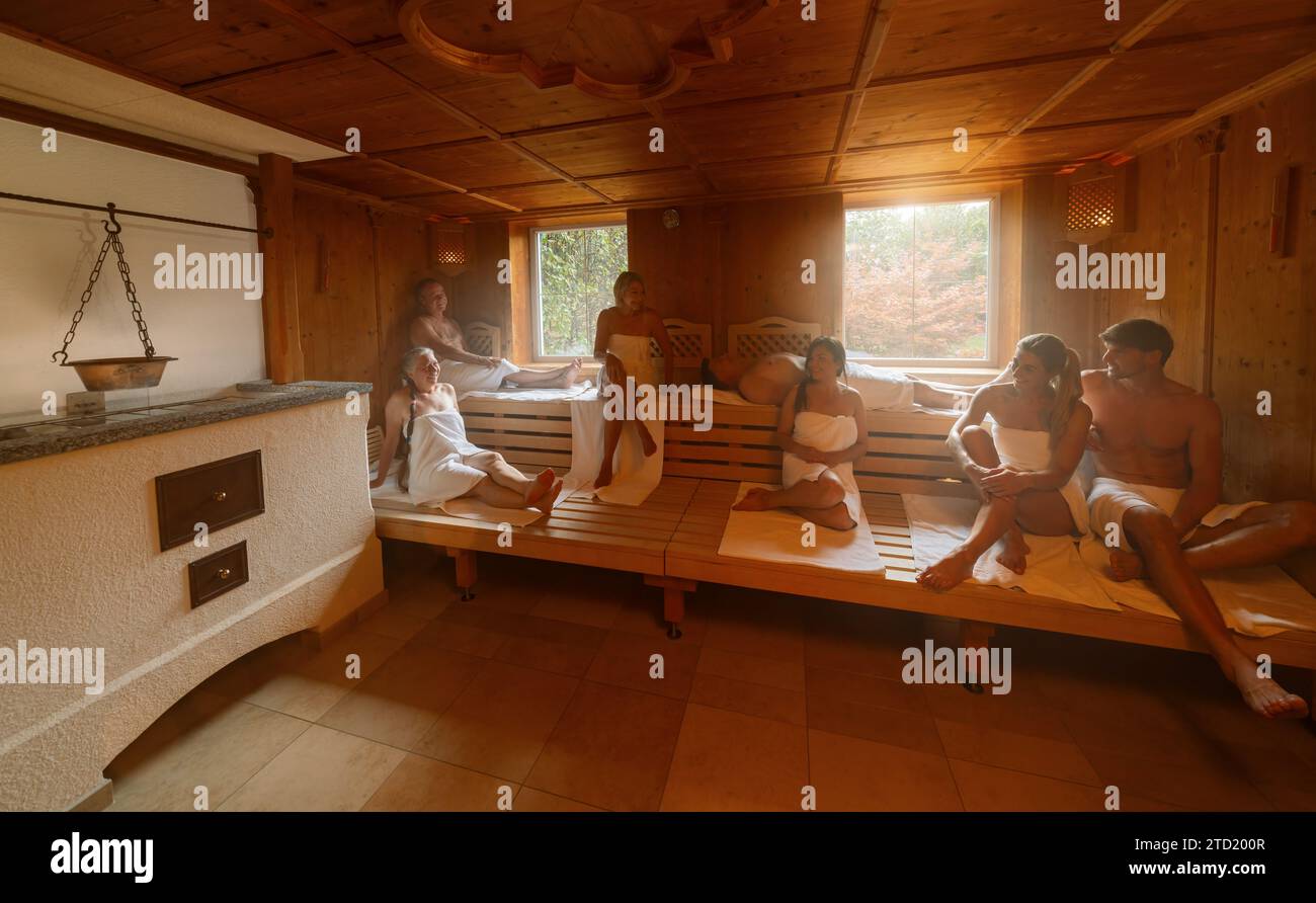 Die Leute entspannen sich in der heißen finnischen Sauna. Dramatisches Licht mit Dampfbad, Spa und Wellness-Konzept. Stockfoto
