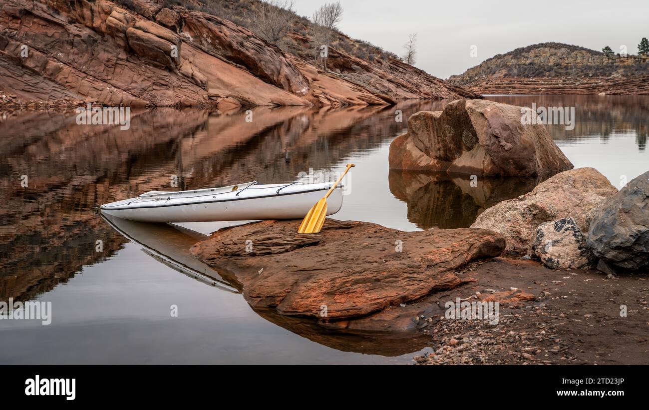 Mit einem hölzernen Paddelboot am felsigen Ufer des Horsetooth Reservoirs in der Nähe von Fort Collins, Colorado, kann man bei niedrigem Wasserstand oder im Winter fahren Stockfoto