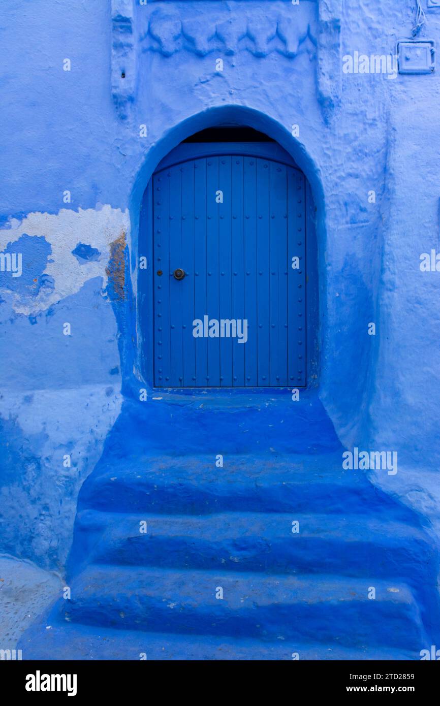 Alte Tür blau bemalt, mit Stufen, in einer schmalen Straße in der Medina von Chefchaouen, Marokko Stockfoto