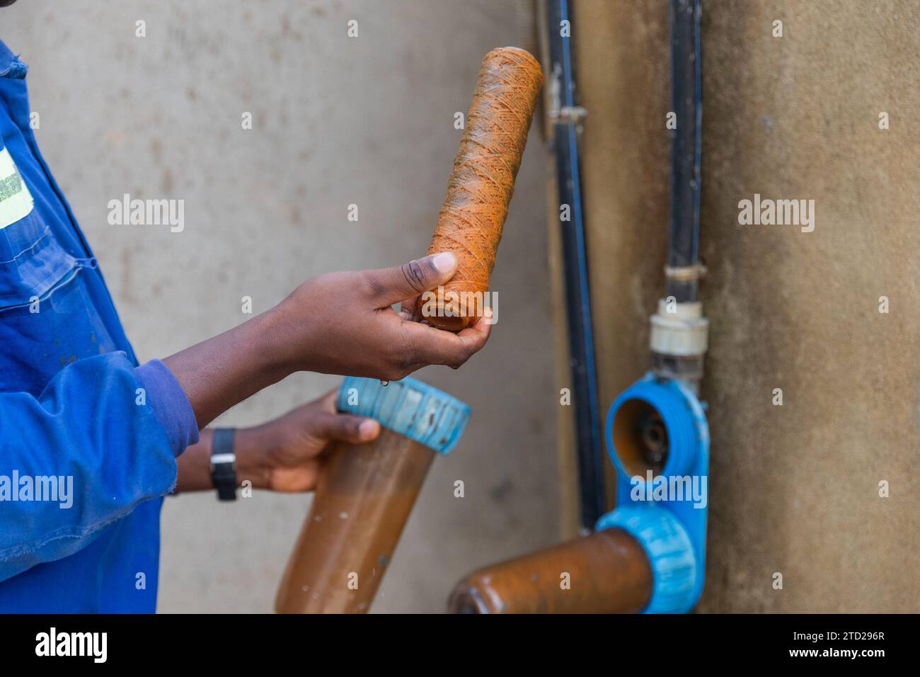 Arbeiter mit schwarzem Kragen zeigen schmutzige, rostige Filter, die gewechselt werden müssen. Stockfoto