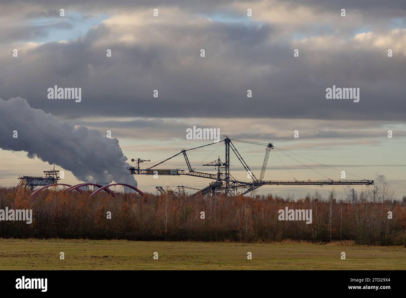 Blick auf einen riesigen Überladestapler vor einem dampfenden Kraftwerk Stockfoto